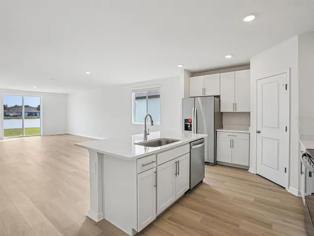 a kitchen with white cabinets and sink
