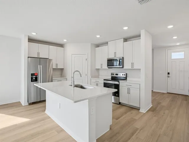 a kitchen with stainless steel appliances granite countertop a sink stove and refrigerator