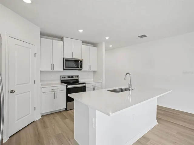a kitchen with a sink a microwave and cabinets