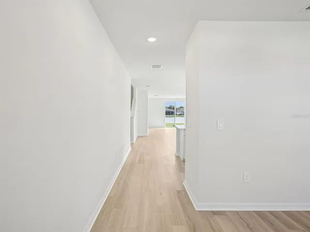 a view of a hallway with wooden floor