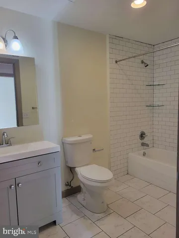 a bathroom with a granite countertop toilet a sink and a mirror