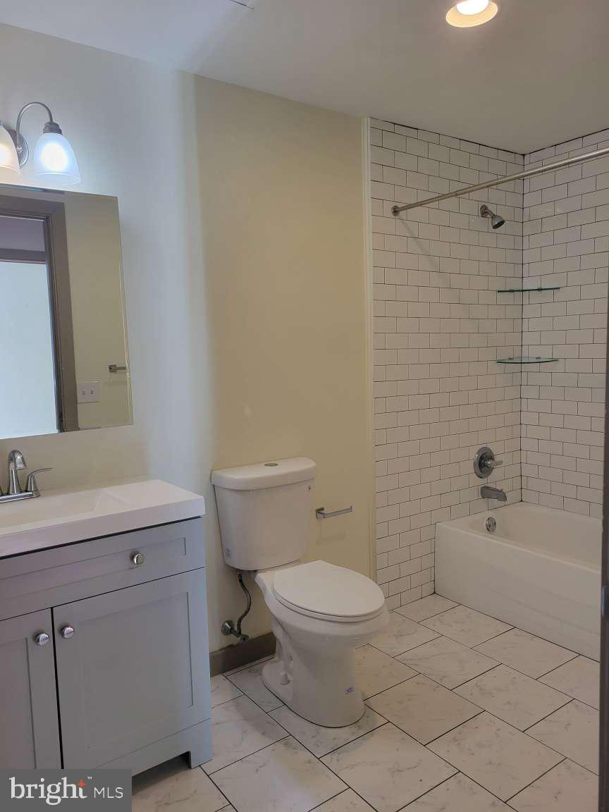 511 North Broad Street, Unit 505 Philadelphia, PA 19123 - Photo 12 of 23 a bathroom with a granite countertop toilet a sink and a mirror