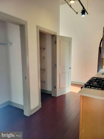 a view of a kitchen with a fridge and wooden floor