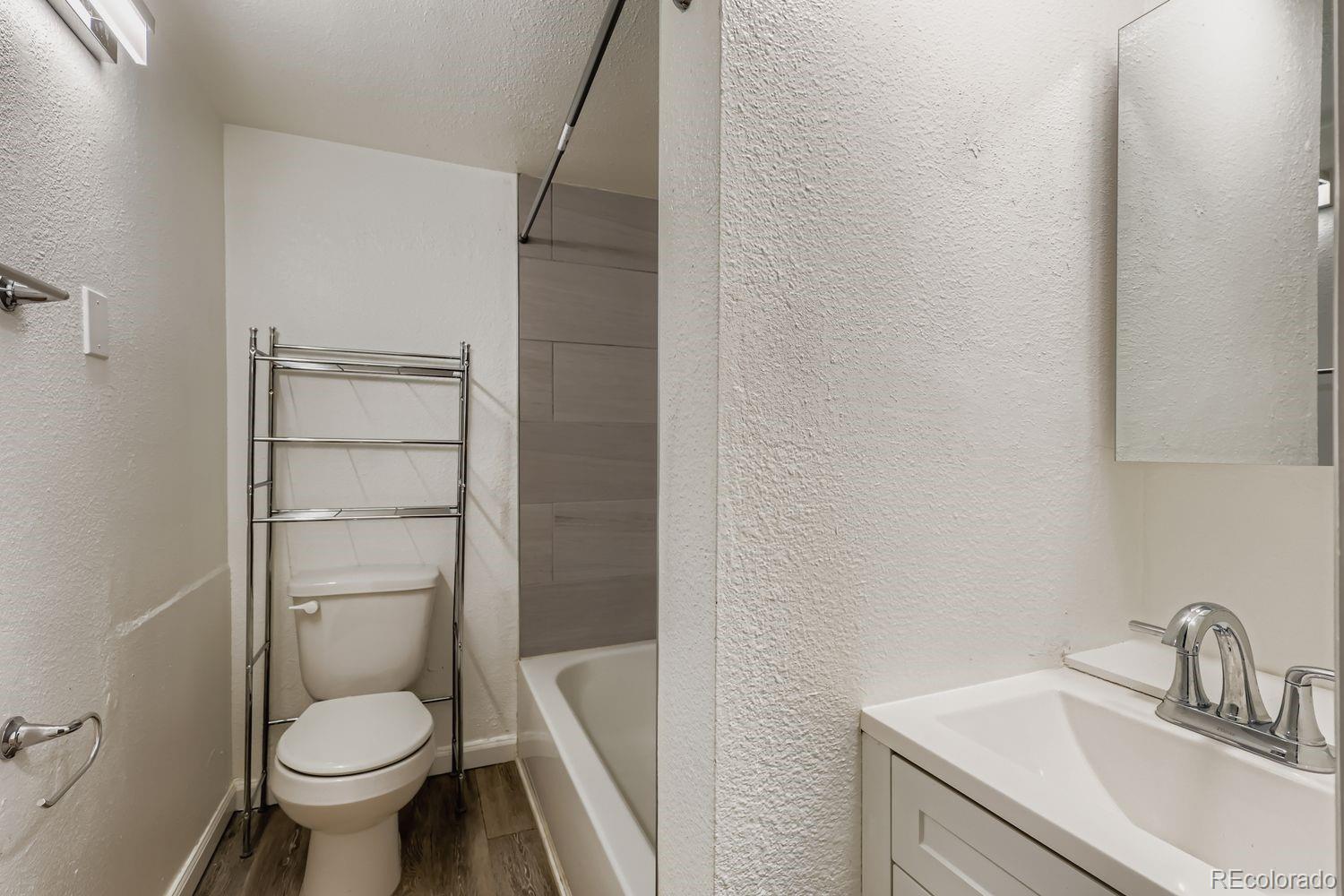 3515 North Williams Street, Unit 3517 Denver, CO 80205 - Photo 15 of 29 a bathroom with a granite countertop toilet a sink and a mirror