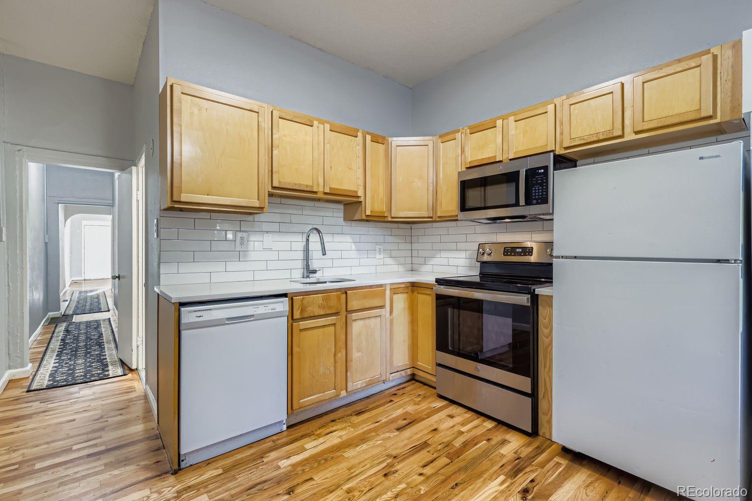 3515 North Williams Street, Unit 3517 Denver, CO 80205 - Photo 8 of 29 a kitchen with stainless steel appliances granite countertop a stove a sink and a refrigerator