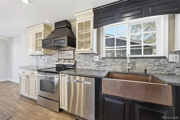 a kitchen with stainless steel appliances granite countertop a stove and a wooden floors