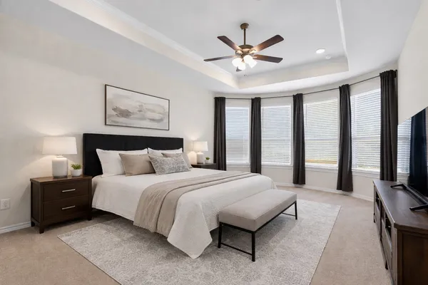 a spacious bedroom with a bed and a flat screen tv