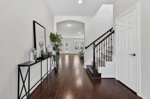 a hallway with wooden floor and stairs