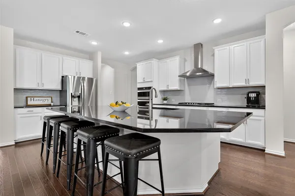 a kitchen with kitchen island white cabinets and stainless steel appliances