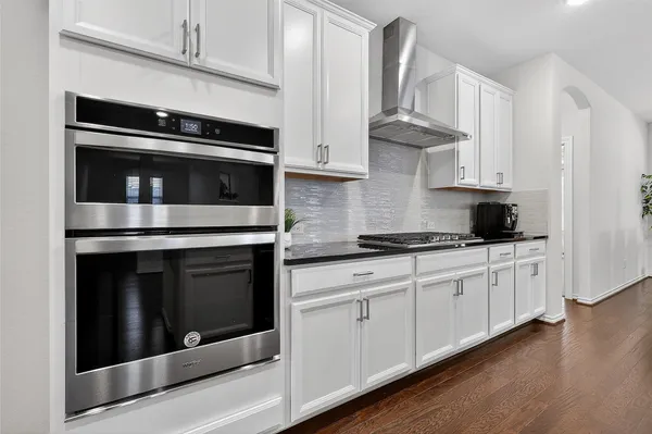 a kitchen with stainless steel appliances granite countertop white cabinets and black appliances