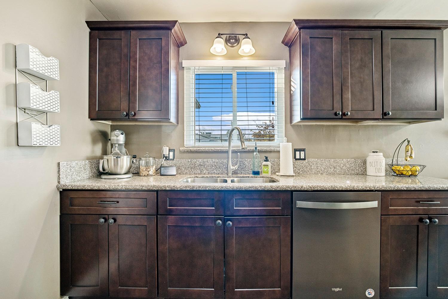 5780 North Angus Street Fresno, CA 93710 - Photo 12 of 41 a kitchen with granite countertop wooden cabinets a sink and dishwasher