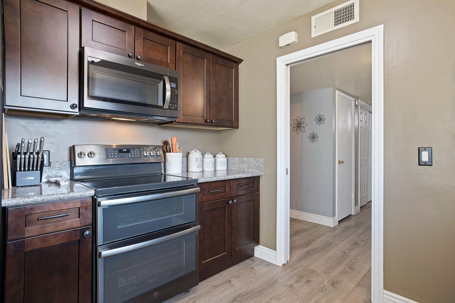 5780 North Angus Street Fresno, CA 93710 - Photo 13 of 41 a kitchen with stainless steel appliances granite countertop a stove and a microwave