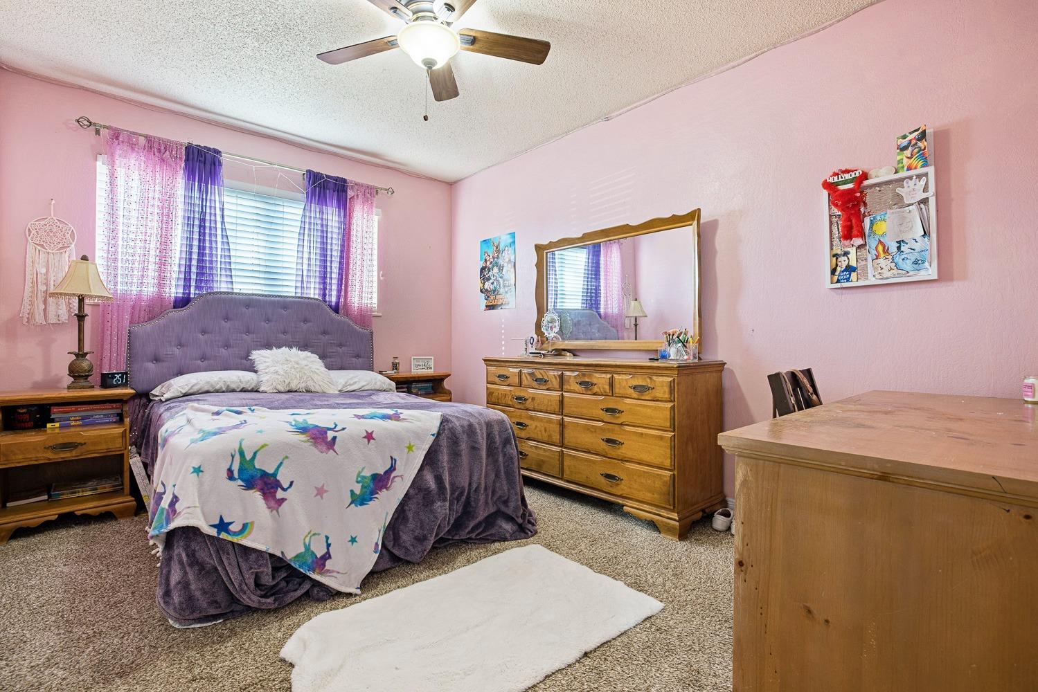 5780 North Angus Street Fresno, CA 93710 - Photo 16 of 41 a bedroom with a bed and a chandelier