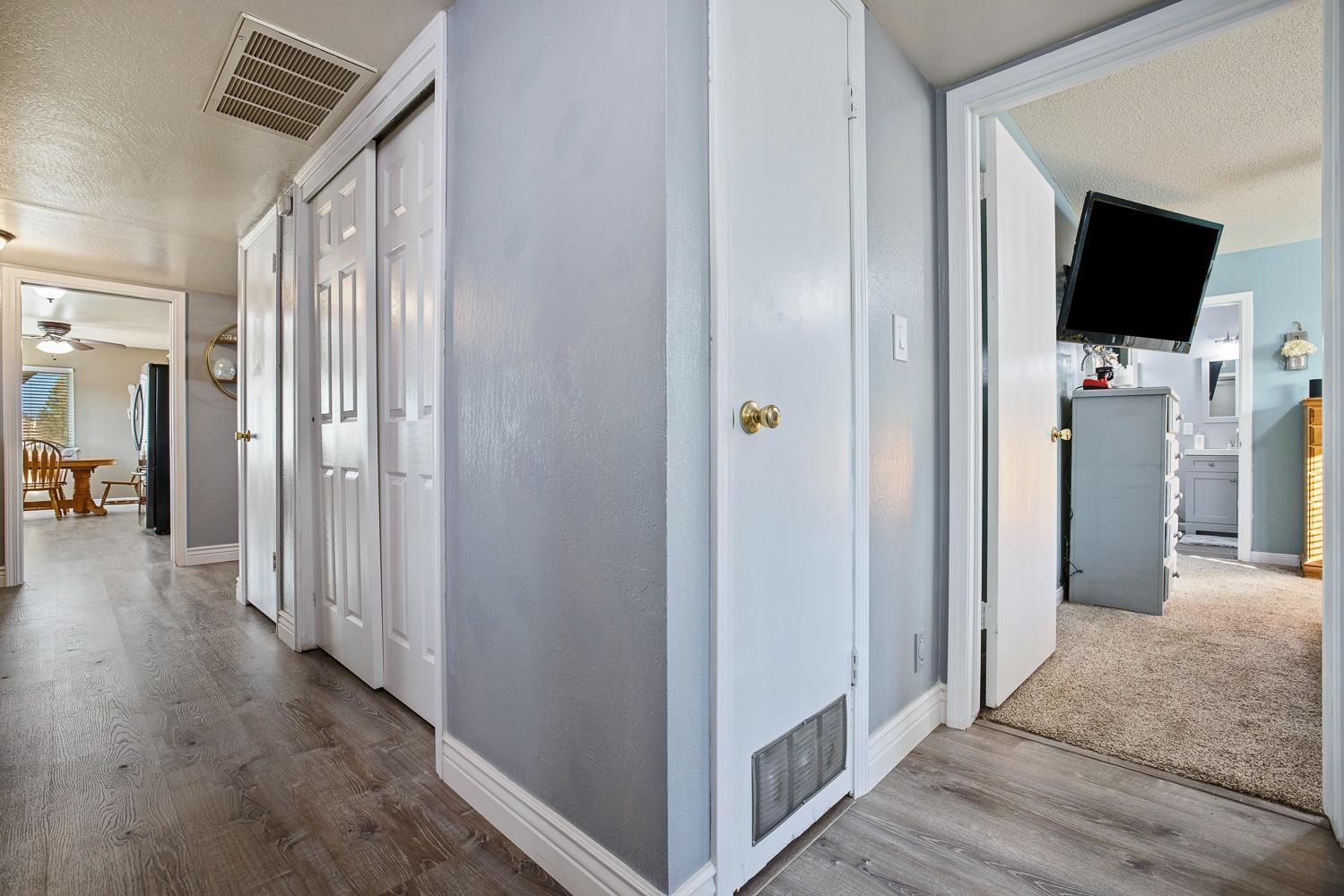 5780 North Angus Street Fresno, CA 93710 - Photo 26 of 41 a view of a hallway with wooden floor and a flat screen tv