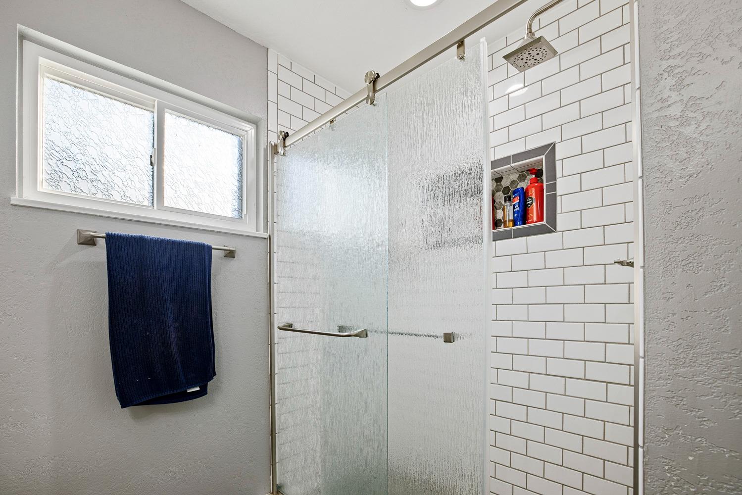 5780 North Angus Street Fresno, CA 93710 - Photo 28 of 41 a bathroom with a painting on the wall and a shower