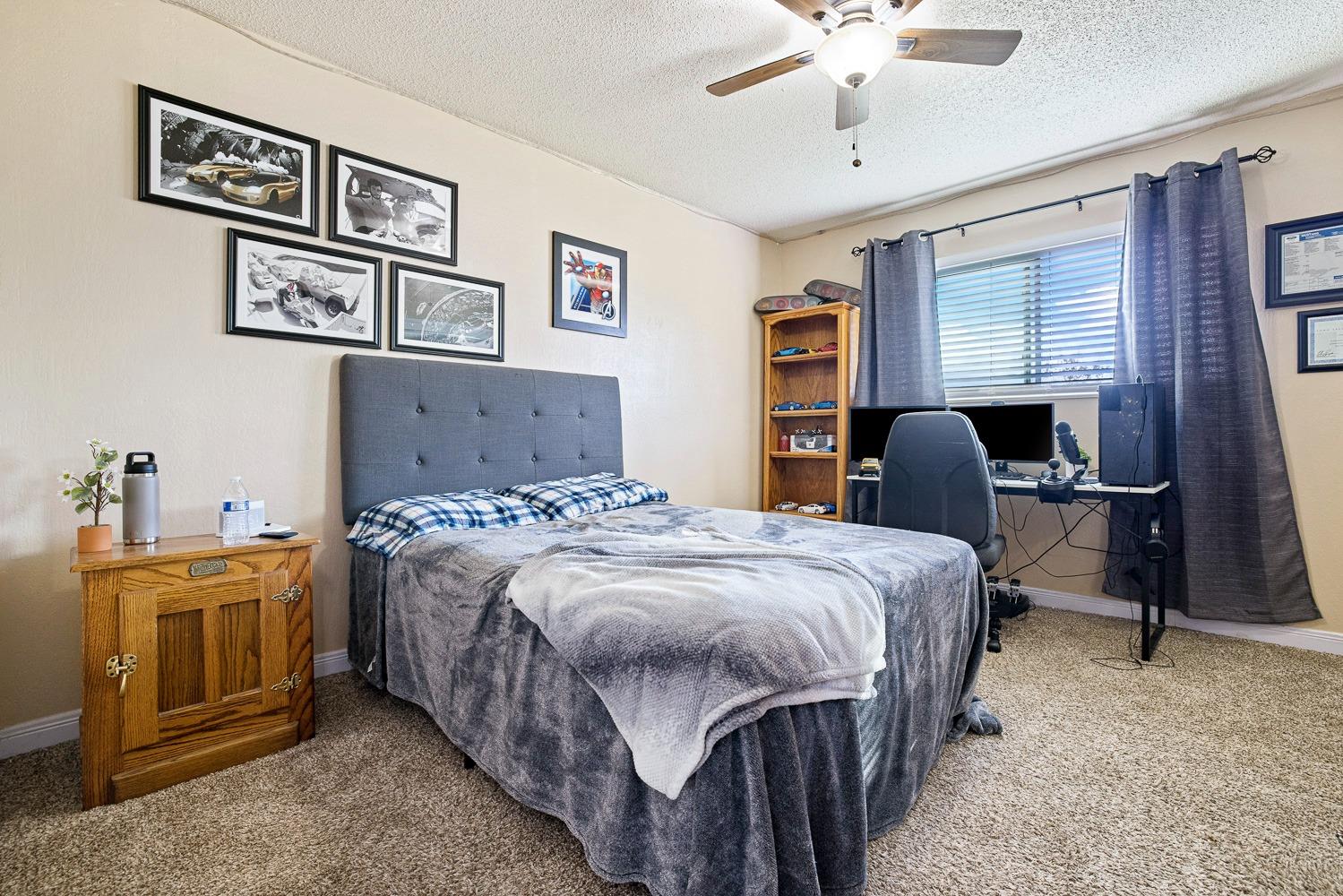 5780 North Angus Street Fresno, CA 93710 - Photo 29 of 41 a bedroom with a bed and a chandelier