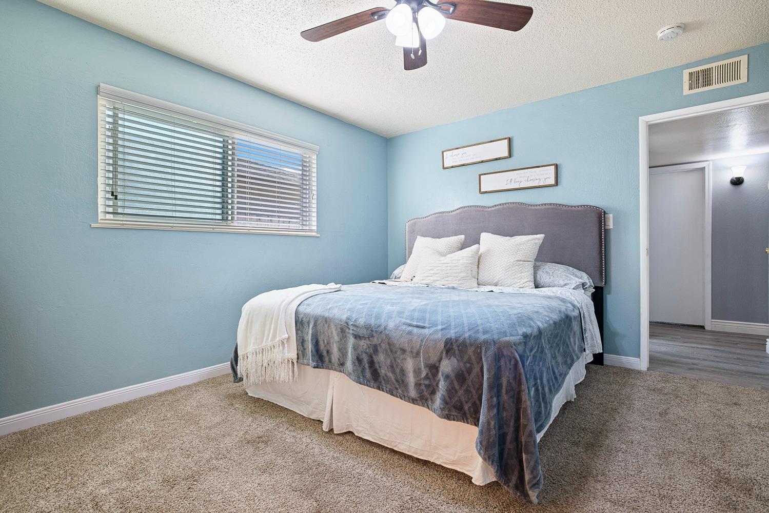 5780 North Angus Street Fresno, CA 93710 - Photo 32 of 41 a spacious bedroom with a bed and a chandelier