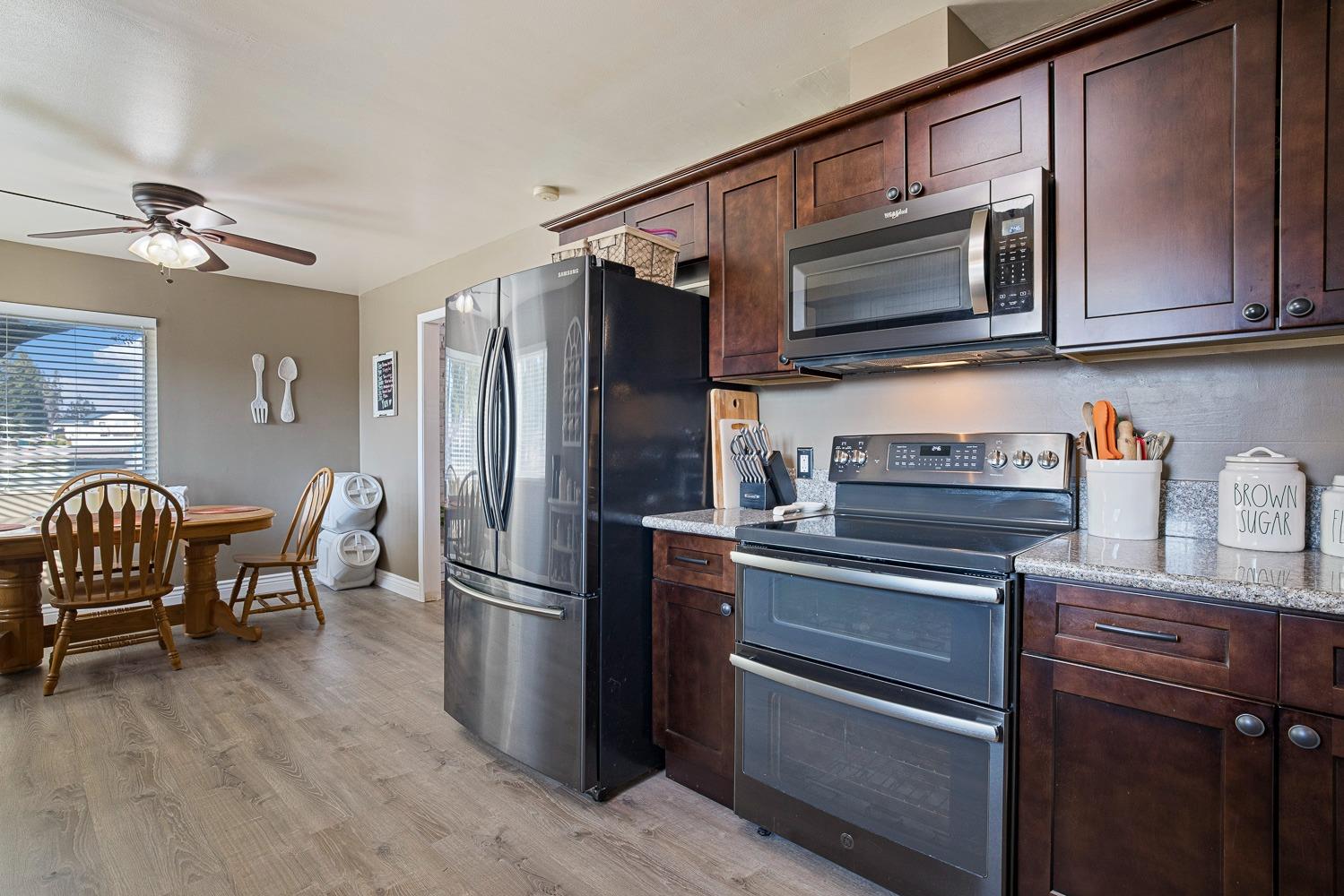 5780 North Angus Street Fresno, CA 93710 - Photo 10 of 41 a kitchen with stainless steel appliances granite countertop a refrigerator microwave and wooden floor