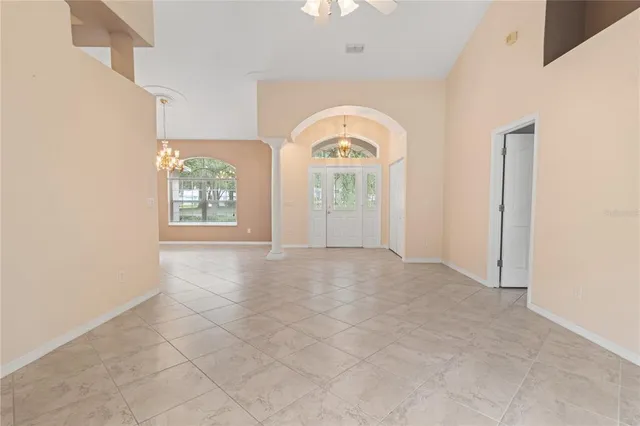 an empty room with fan and windows