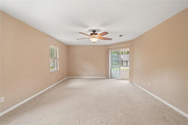 an empty room with a ceiling fan and window