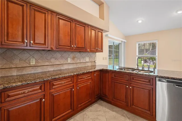a view of kitchen with kitchen island a counter top space a sink stainless steel appliances and cabinets