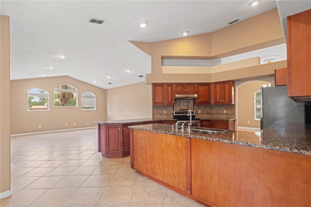 1617 Southeast 29th Terrace Ocala, FL 34471 - Photo 27 of 42 a kitchen with stainless steel appliances granite countertop a sink and a refrigerator