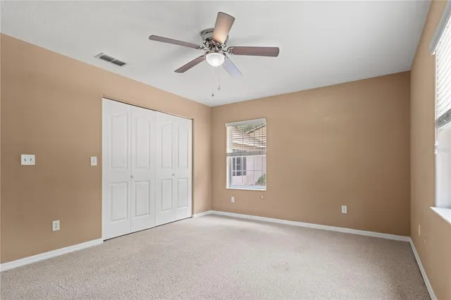 an empty room with a window and a fan