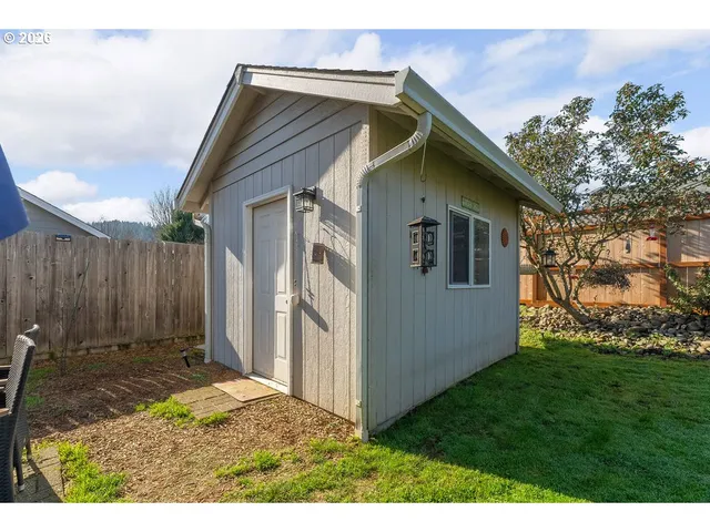 a view of backyard of house with wooden fence