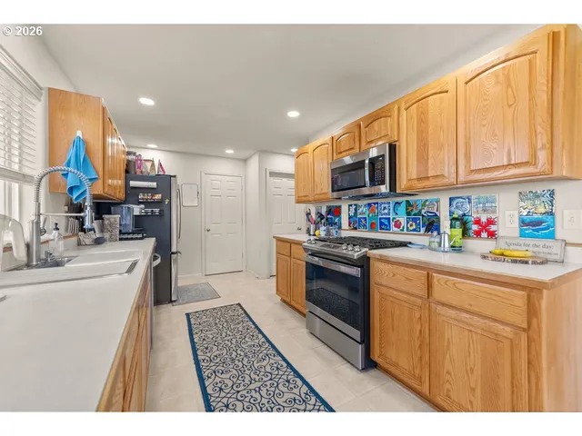 a kitchen with granite countertop a sink stainless steel appliances and cabinets