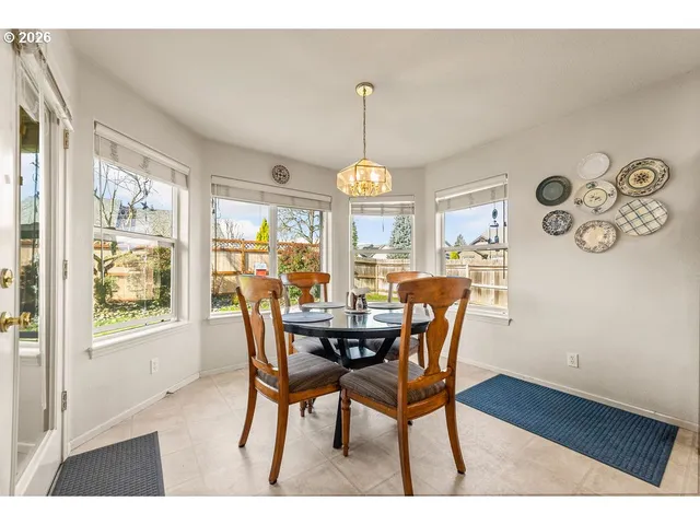 a dining room with furniture a chandelier and wooden floor
