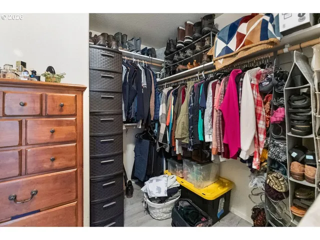 a view of walk in closet with clothes and shoes