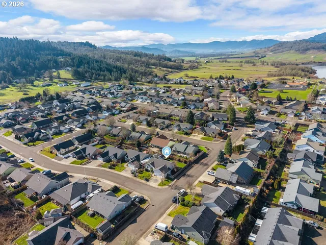 an aerial view of a city with lots of residential buildings and mountain view in back
