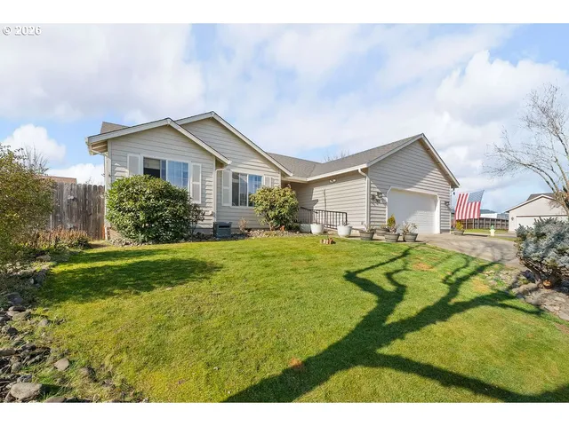 a view of a house with a big yard plants and large trees