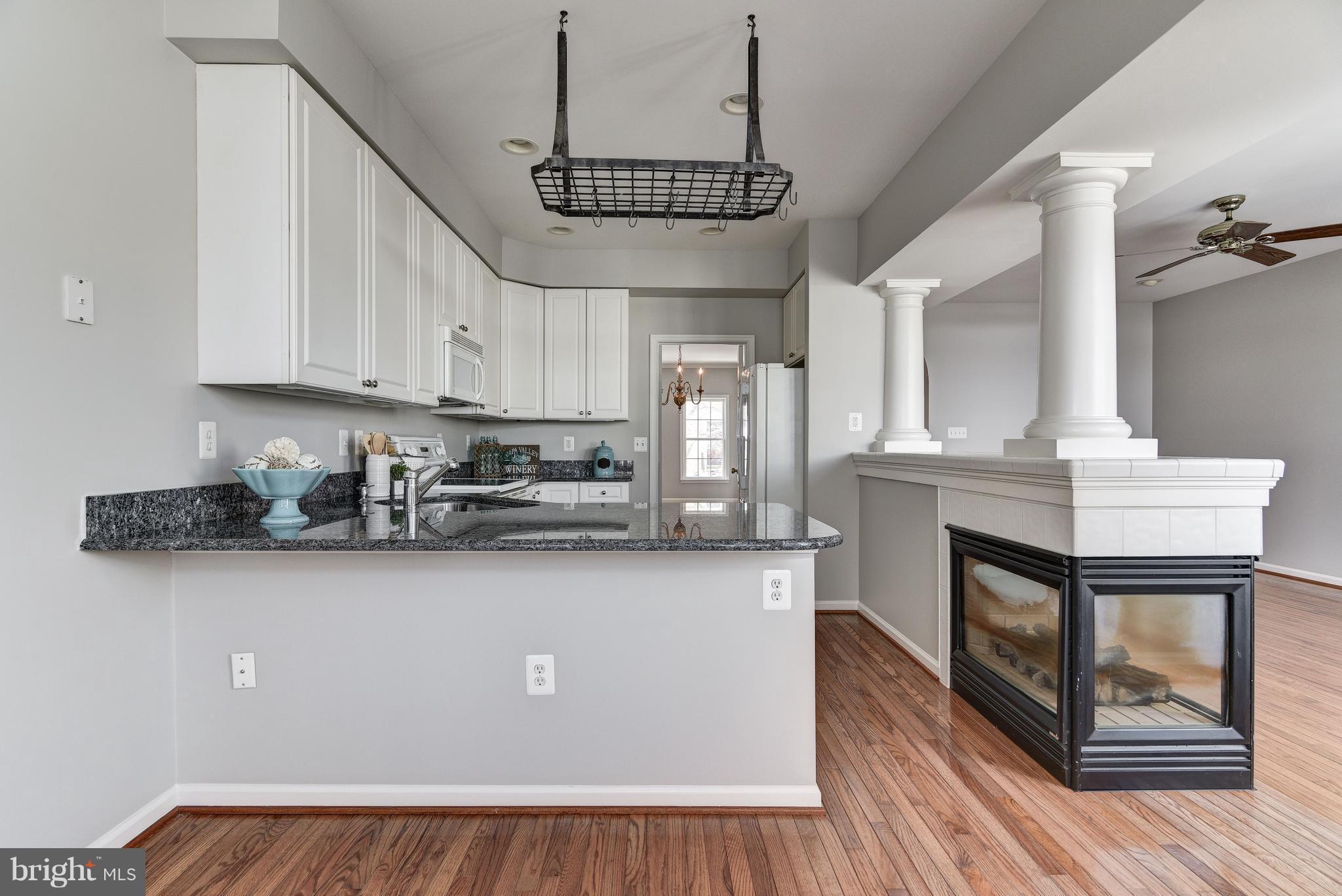 3005 Annas Terrace Frederick, MD 21701 - Photo 7 of 29 a kitchen with stainless steel appliances a sink a stove a refrigerator cabinets and a wooden floor