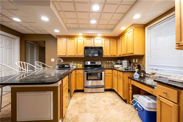 a kitchen with granite countertop a sink and a stove top oven