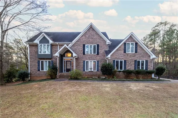 a front view of a house with yard and green space