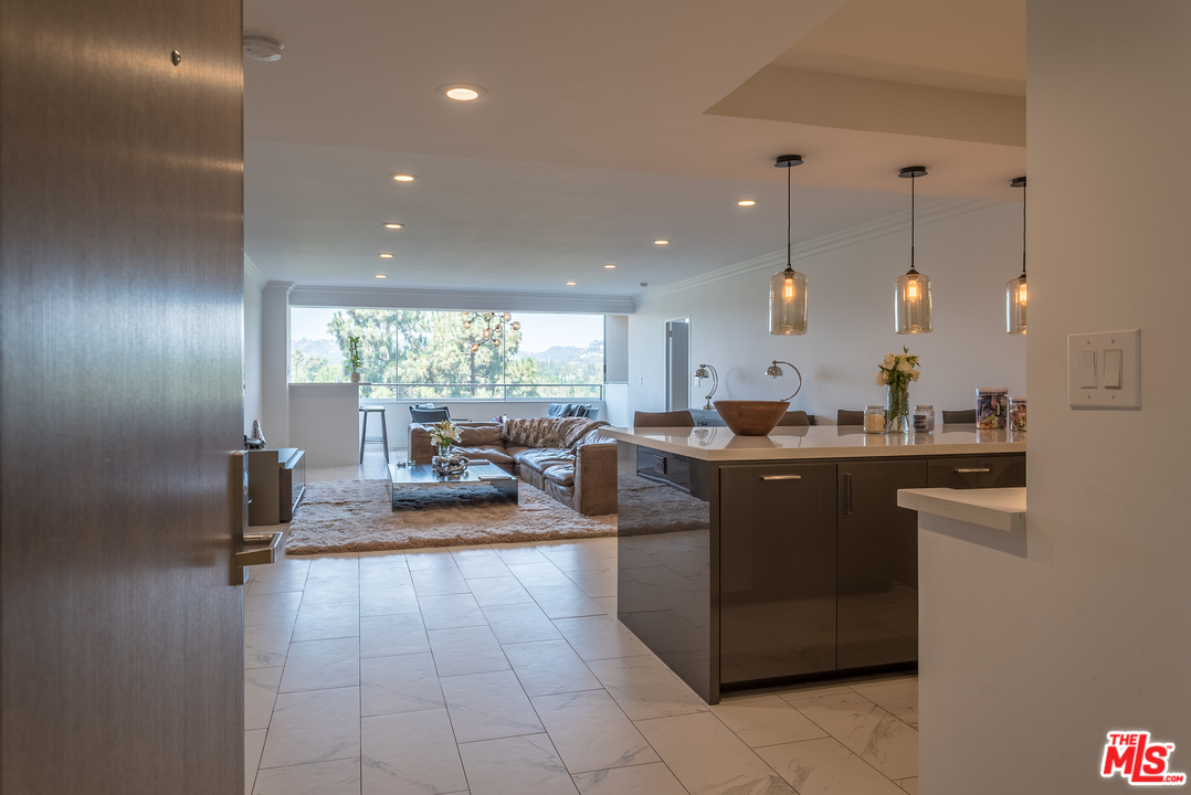 a kitchen with counter top space and living room view
