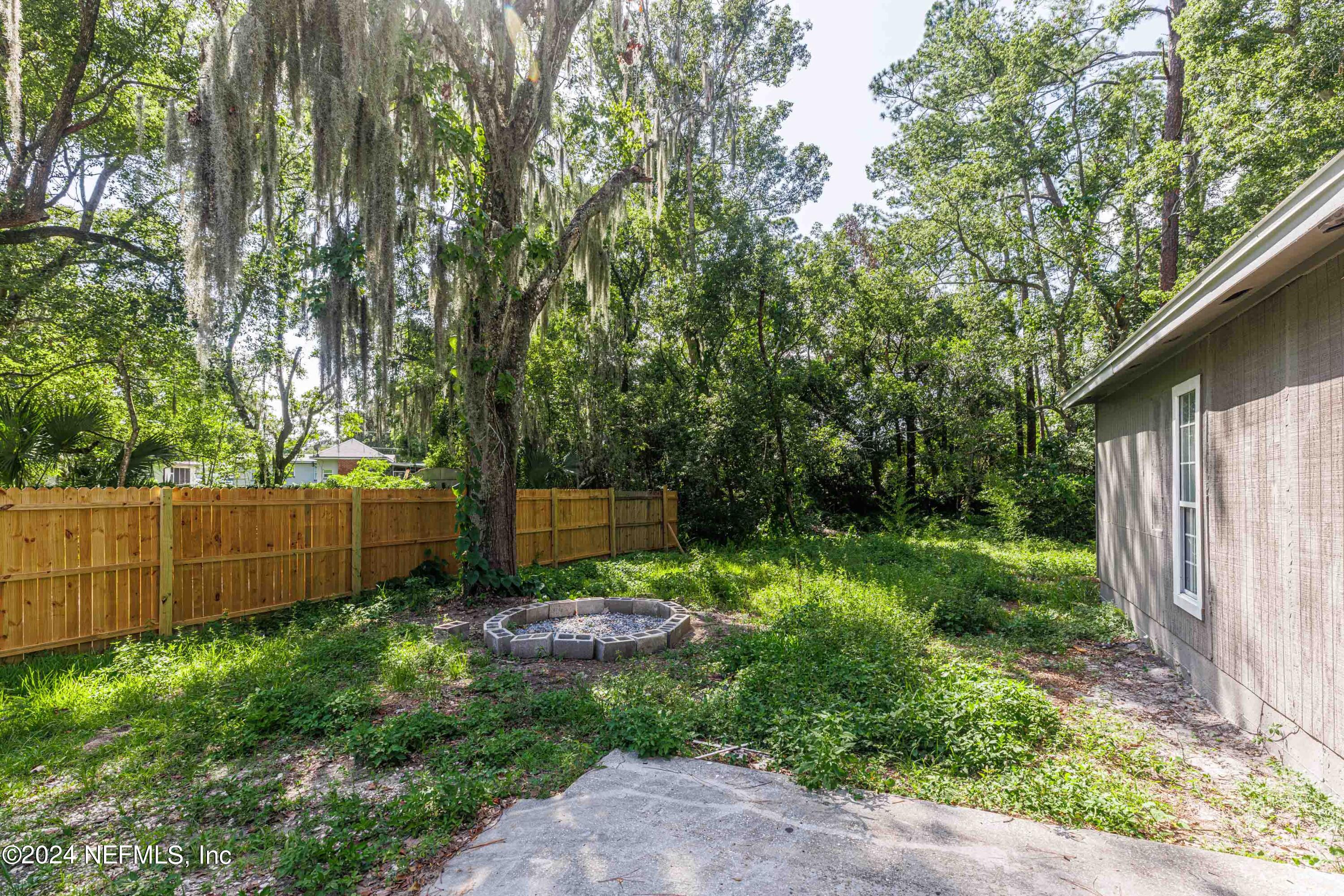 2448 Parental Home Road Jacksonville, FL 32216 - Photo 19 of 21 a view of a backyard with plants and a large tree