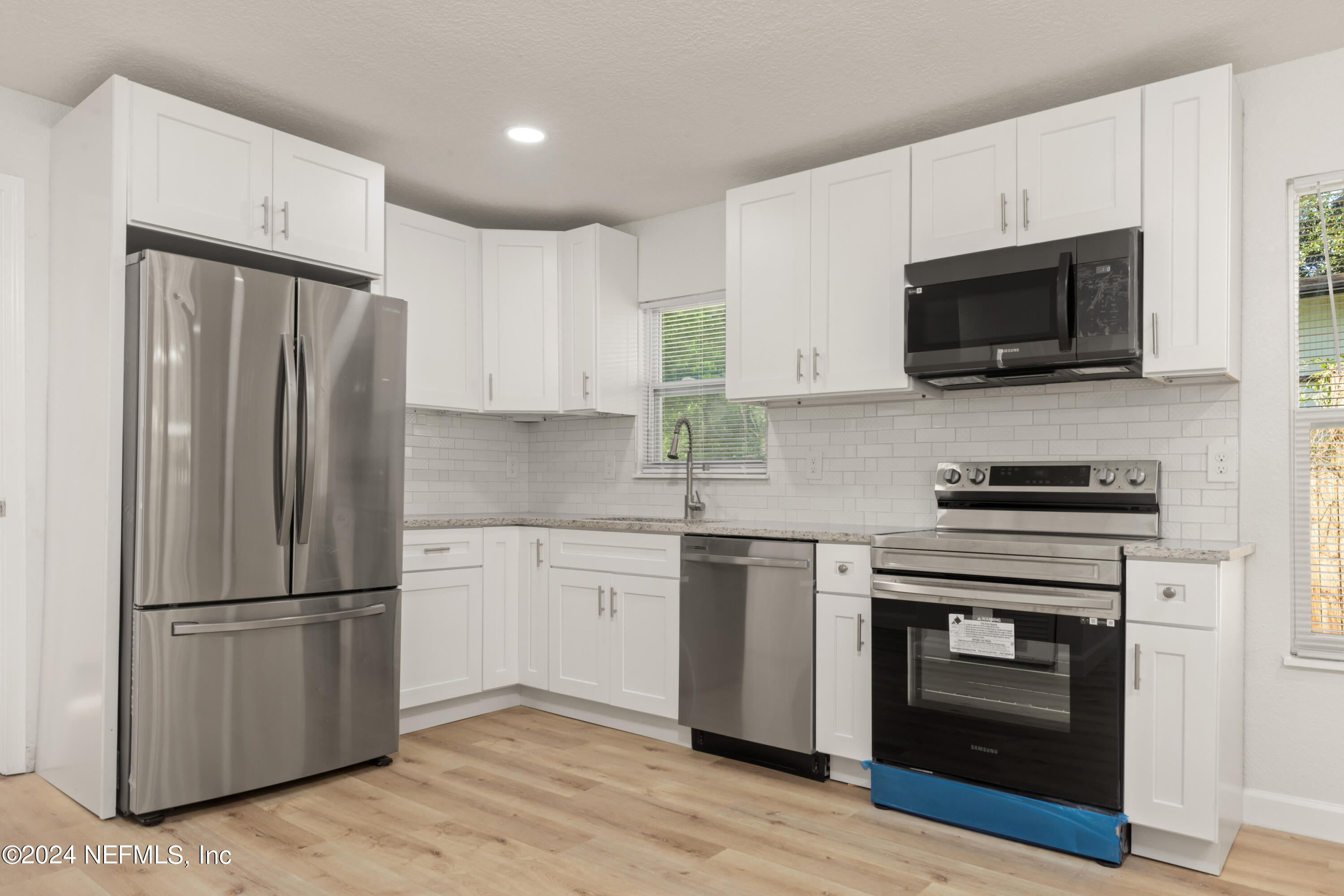 2448 Parental Home Road Jacksonville, FL 32216 - Photo 7 of 21 a kitchen with stainless steel appliances a refrigerator stove and microwave