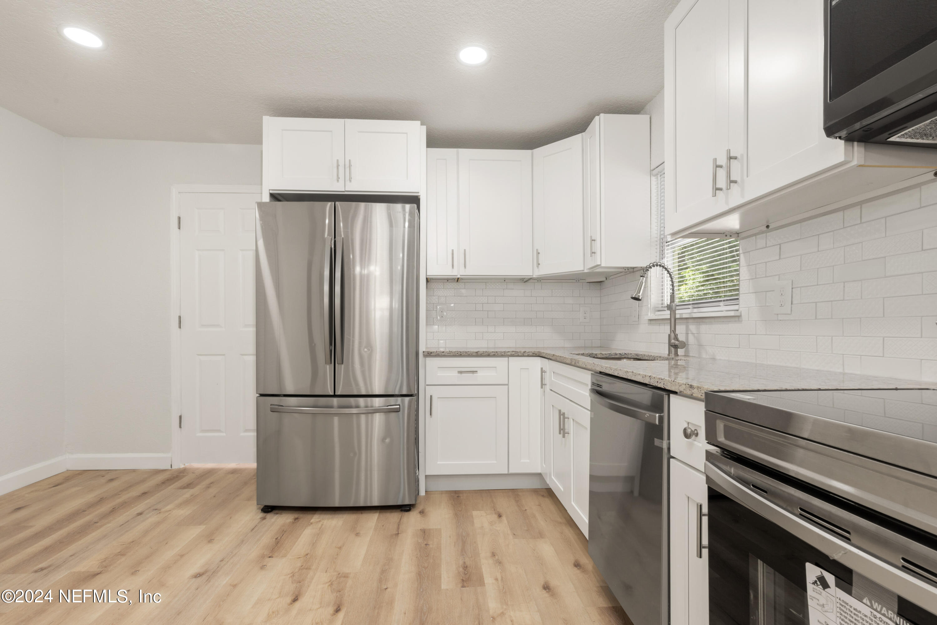 2448 Parental Home Road Jacksonville, FL 32216 - Photo 9 of 21 a kitchen with a refrigerator sink and cabinets
