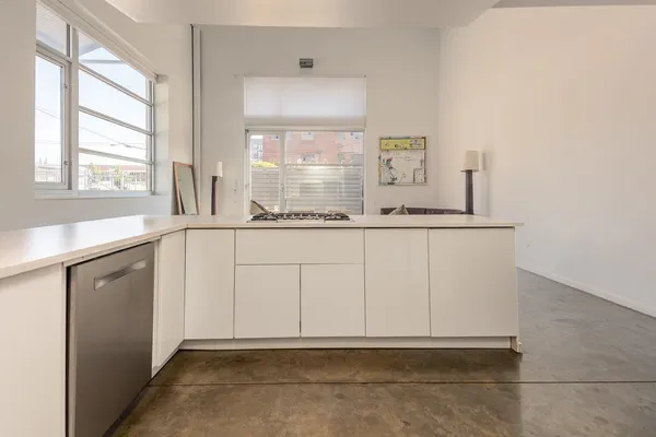 a kitchen with granite countertop a sink and white cabinets