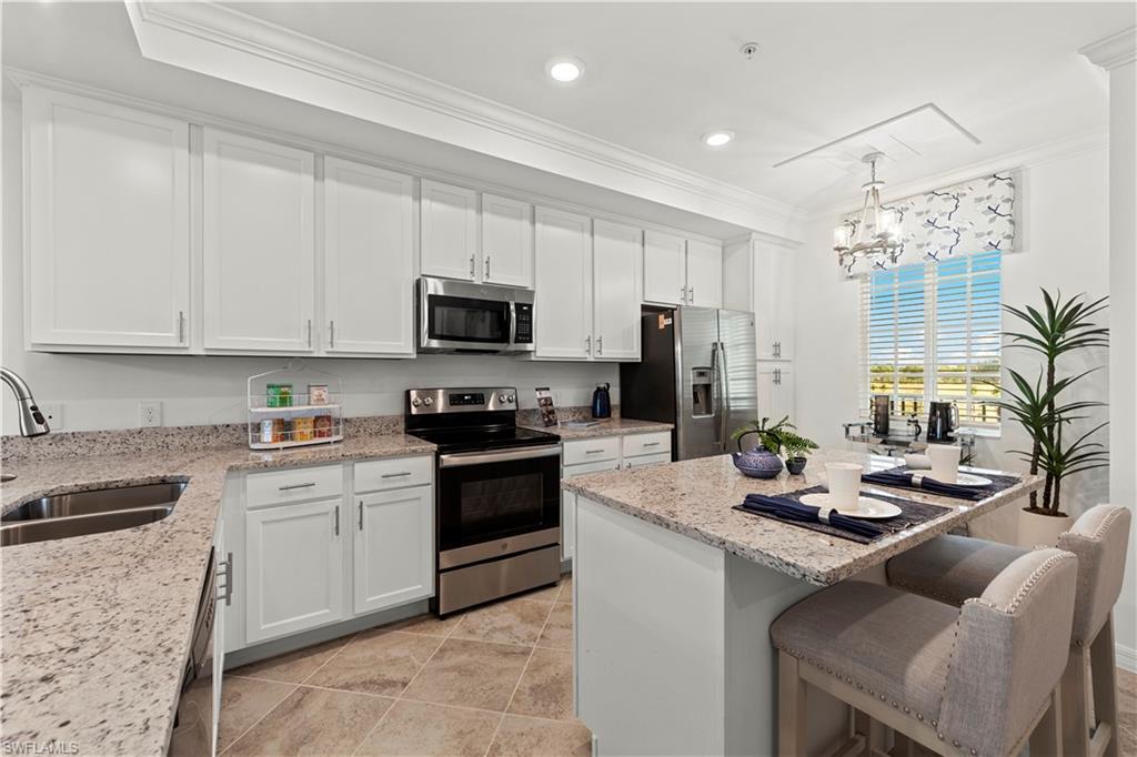 5651 Double Eagle Circle, Unit 4314 Immokalee, FL 34142 - Photo 4 of 20 a kitchen with kitchen island granite countertop a sink appliances cabinets and furniture