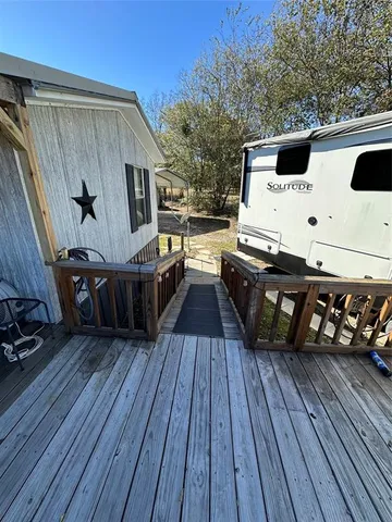 a view of a deck with wooden floor barbeque oven and yard