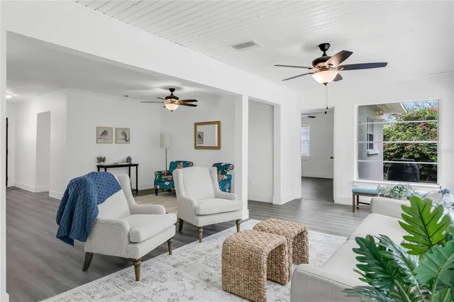 a dining room with wooden floor a chandelier a glass table and chairs