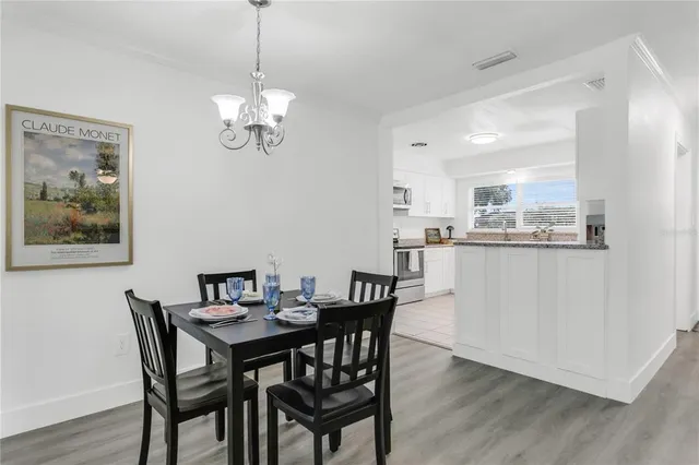 a kitchen with granite countertop white cabinets and stainless steel appliances