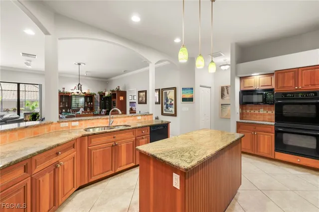 a kitchen with stainless steel appliances kitchen island granite countertop a stove a sink and a wooden cabinets