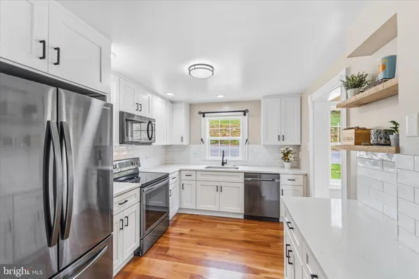 a large kitchen with cabinets stainless steel appliances and a window