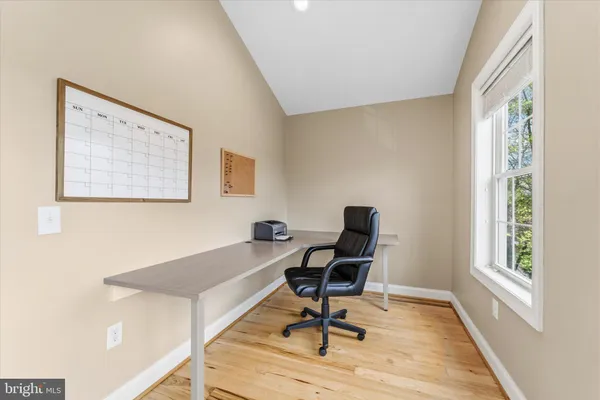 a view of a workspace with furniture and a window
