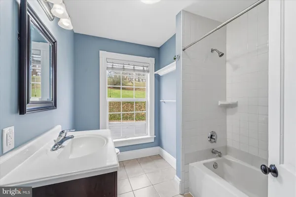 a bathroom with a tub sink and mirror