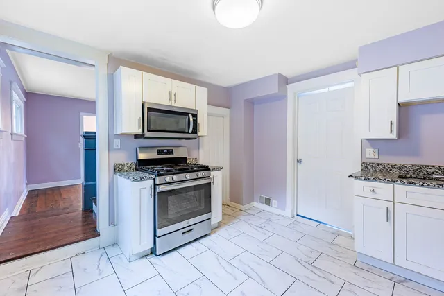 a kitchen with stainless steel appliances granite countertop a stove and a microwave